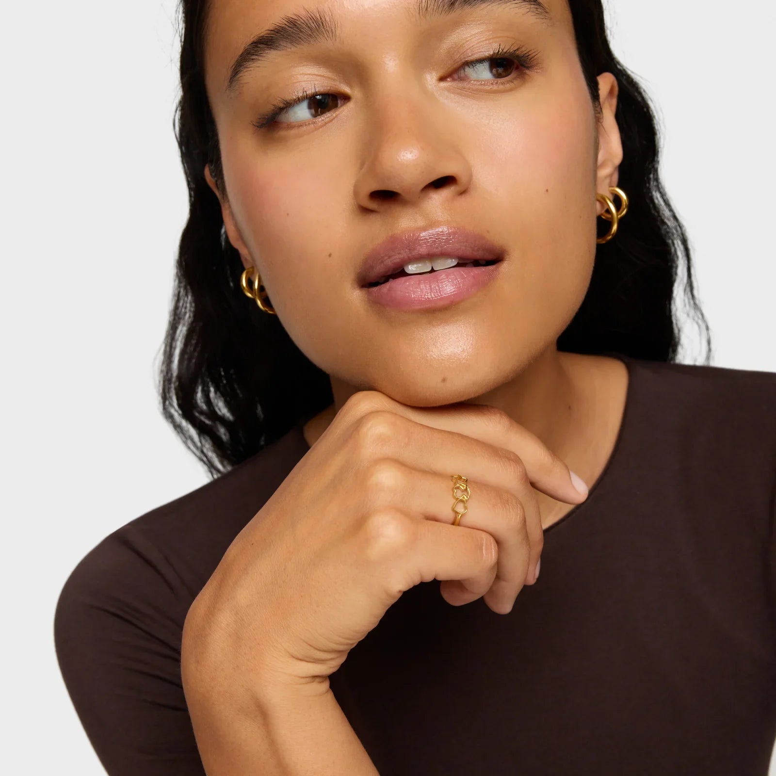 אישה עונדת עגילי זהב וטבעת זהב, צילום תקריב אופנה לאתר CHOZEN