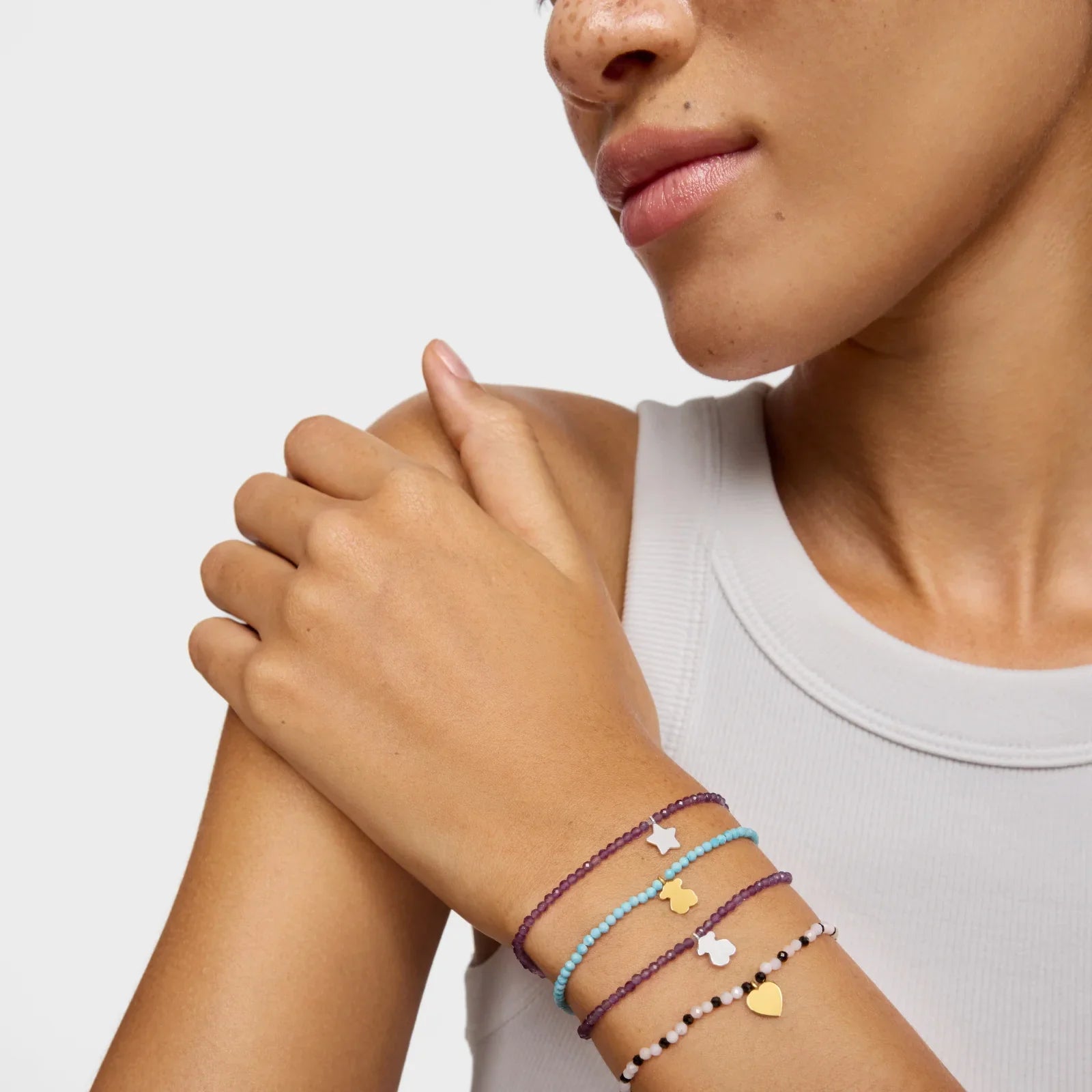 אישה עונדת צמידים צבעוניים עם תליוני לב וכוכב, צילום קוקל לקולקציית תכשיטים של CHOZEN