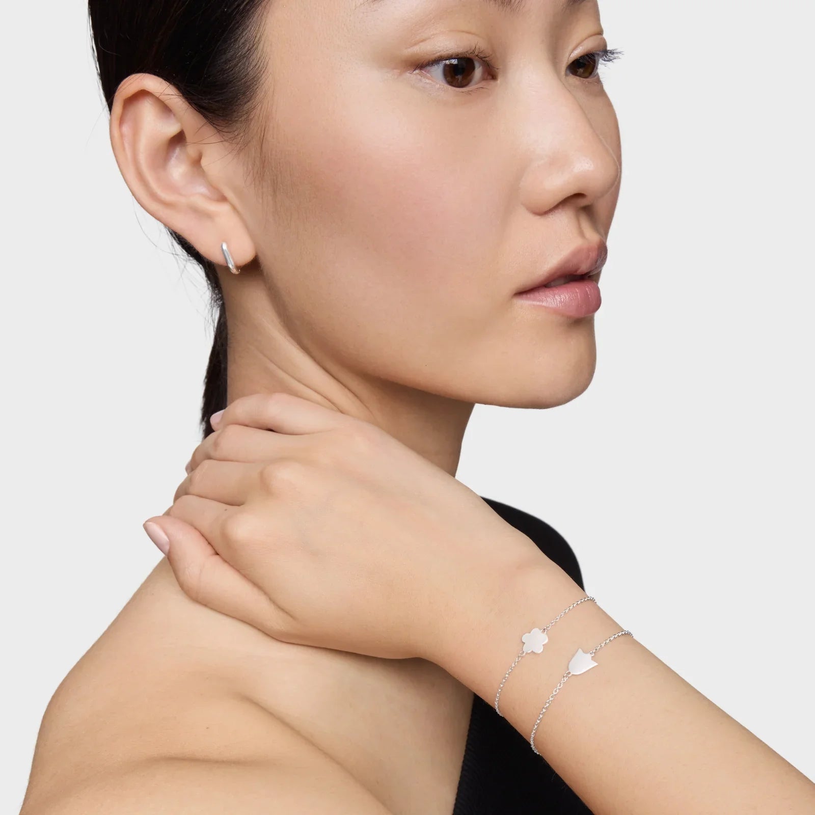 אישה עונדת צמידי כסף דקים ועגיל כסף עדין, תכשיטי אופנה יוקרתיים CHOZEN