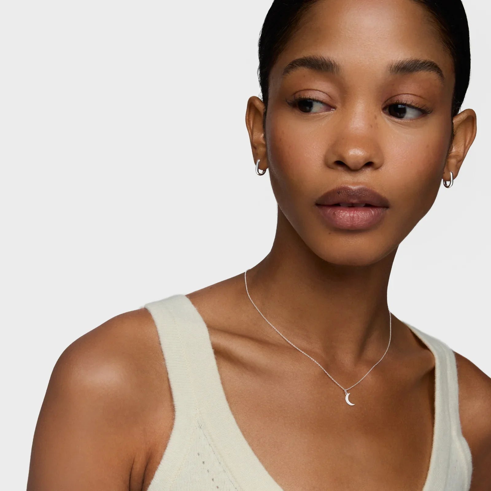 דוגמנית עונדת שרשרת כסף עדינה עם תליון ירח ועגילי חישוק, צילום תדמית CHOZEN