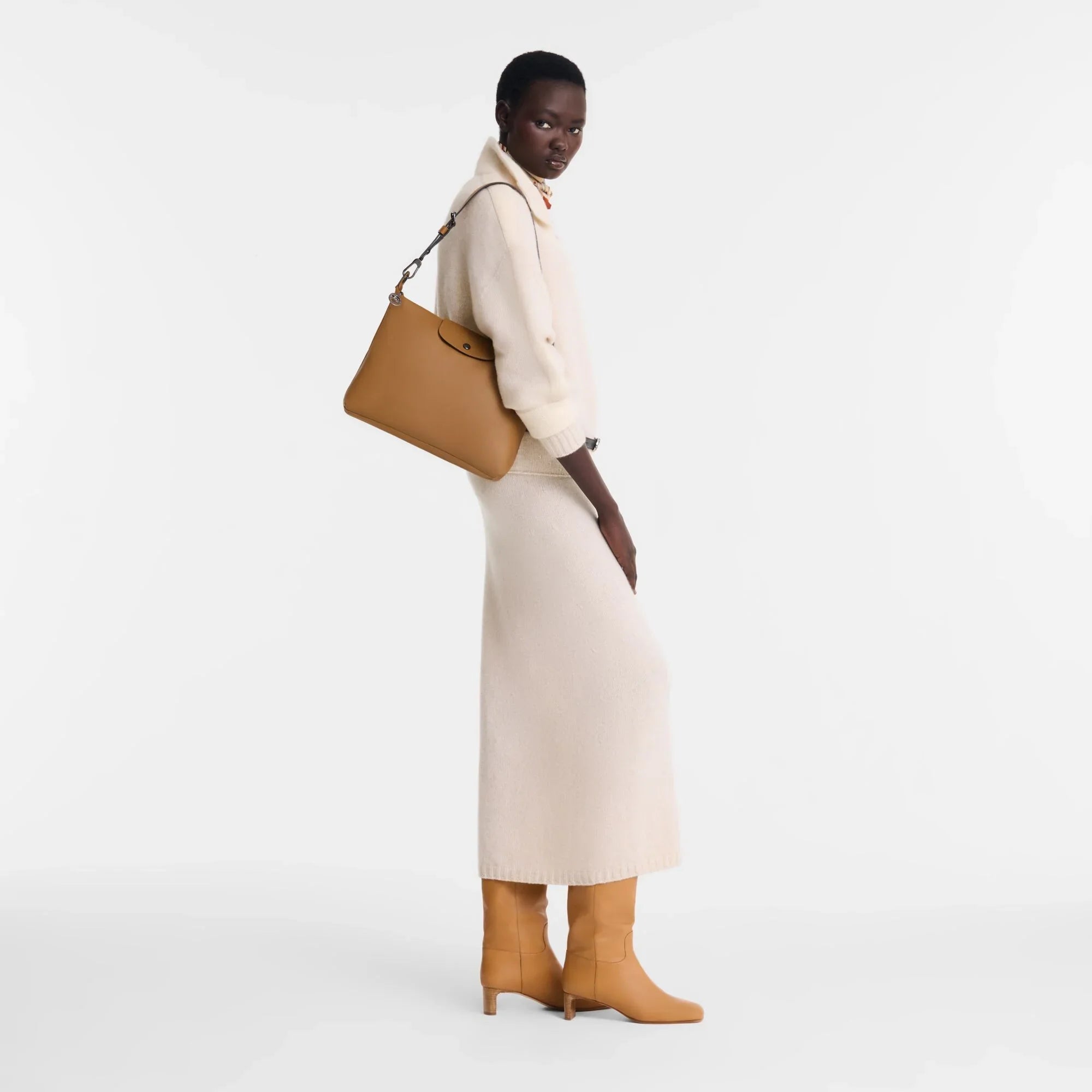 דוגמנית עם שמלה וסוודר קרם, נעלי עקב ותיק חום, אופנה יוקרתית CHOZEN