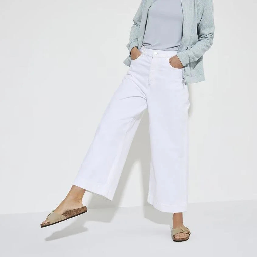 אישה לובשת מכנסיים לבנים רחבים וחולצה בהירה, אופנת קיץ CHOZEN