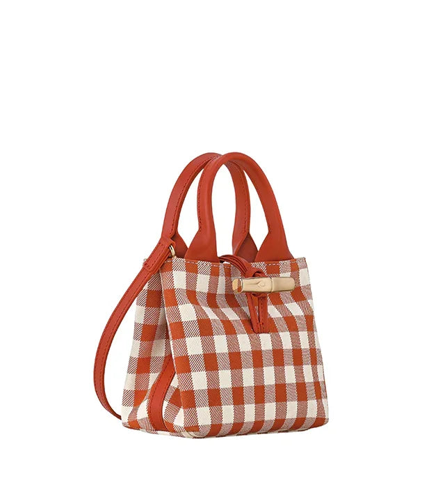 תיק יד אופנתי בסגנון משובץ בצבעים חום ולבן, רצועה וחלקים מעור, מוצג ב-CHOZEN