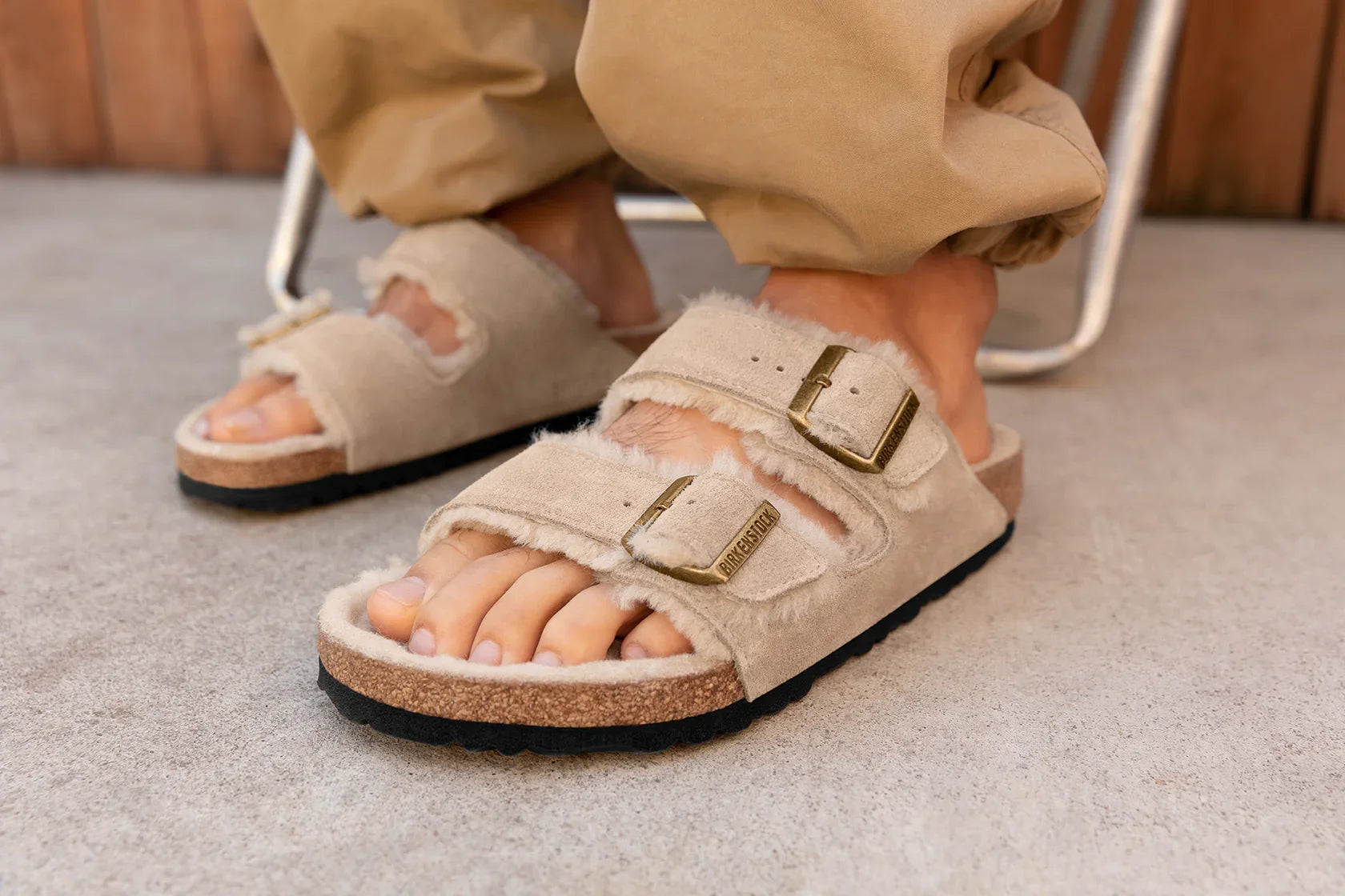 סנדלי בירקנשטוק בצבע בז' פרווה, כפכפים אופנתיים על רצפה, מותגים מובילים CHOZEN