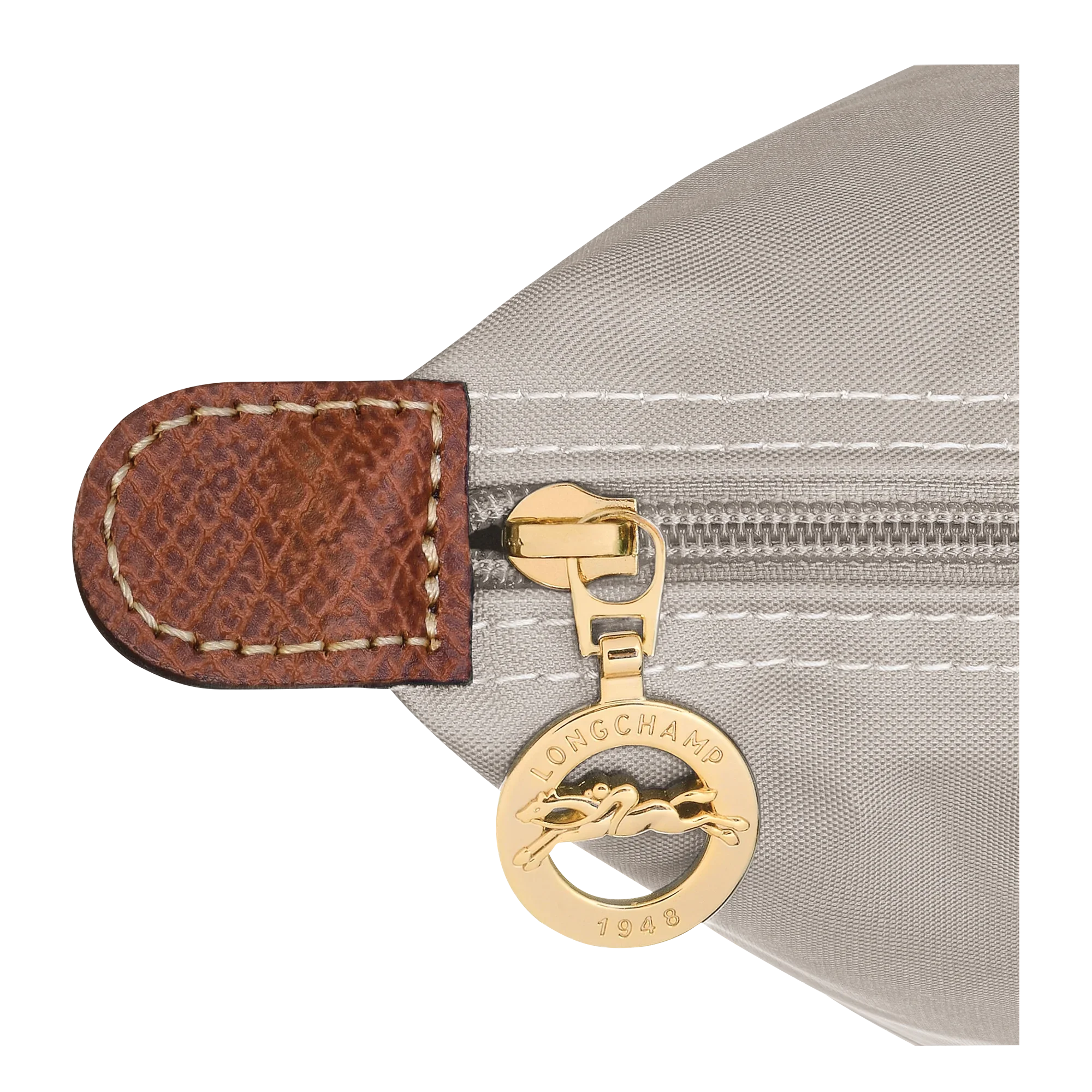 תקריב רוכסן תיק Longchamp זהוב עם תג עור חום, מבית קבוצת אלפא ב-CHOZEN