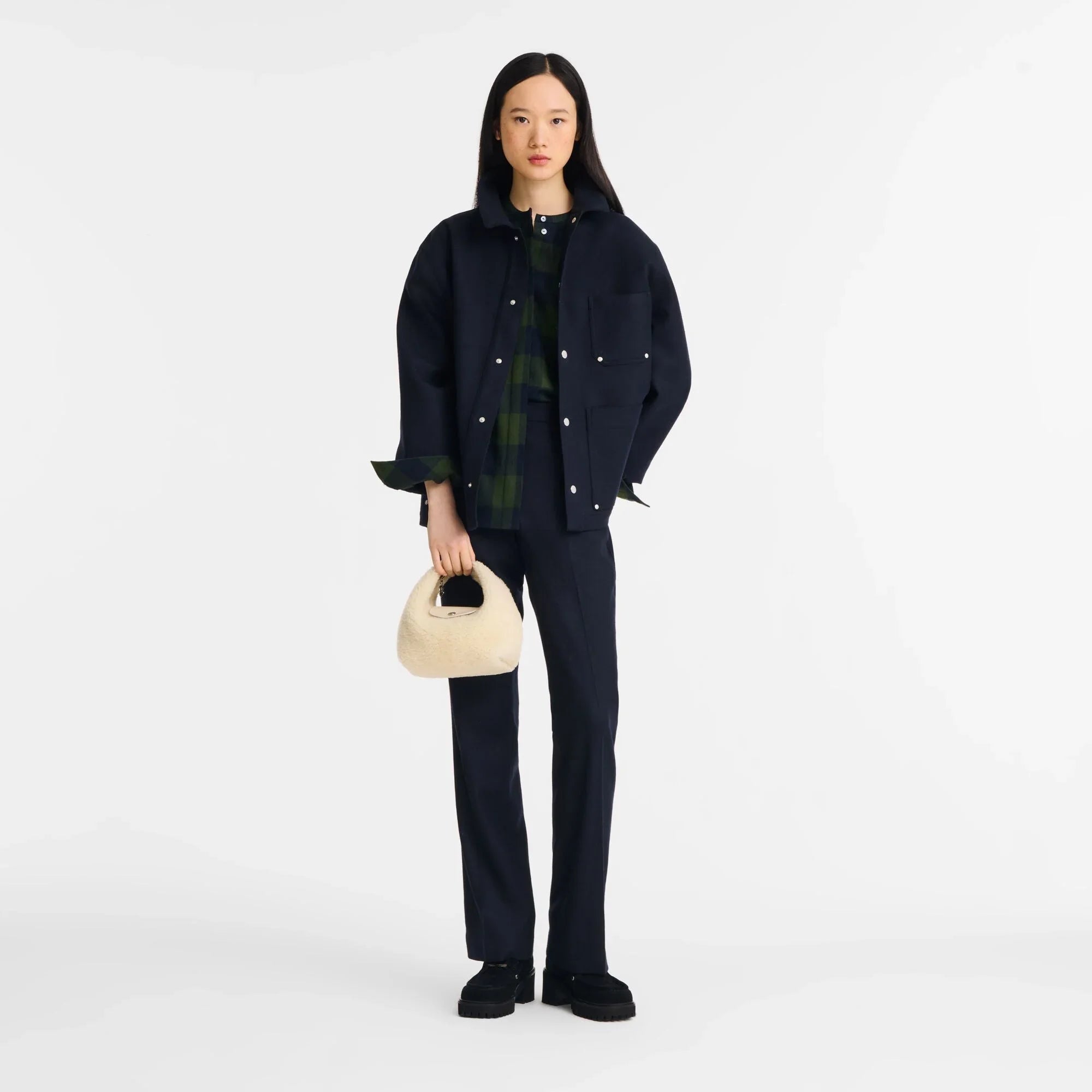 דוגמנית בשיק אורבני לובשת חליפה כהה, מחזיקה תיק אופנתי, צילום קמפיין CHOZEN