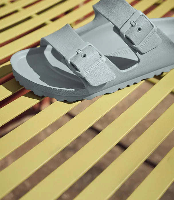 סנדל בירקנשטוק אפור על ספסל צהוב, מותג על באתר CHOZEN