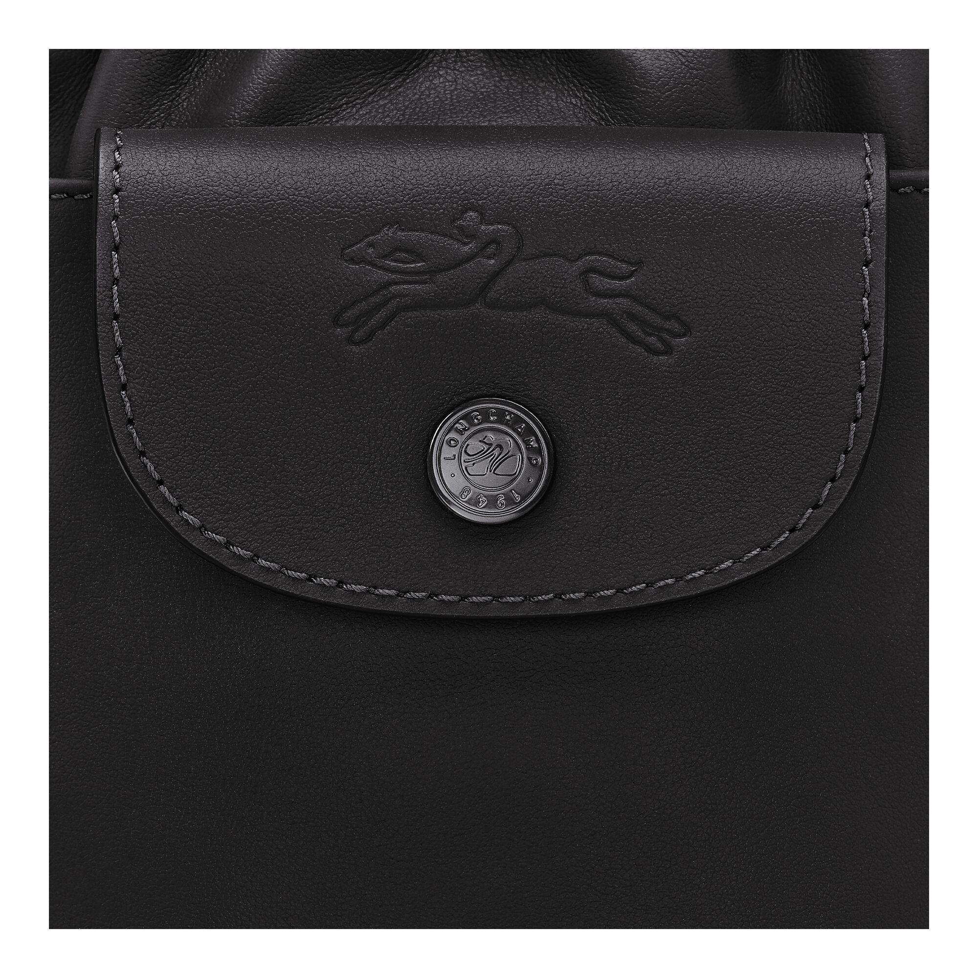 תקריב של תיק עור שחור מבית מותג יוקרה, כפתור עם לוגו ובולטות של סמל הקפיצה, CHOZEN, קבוצת אלפא