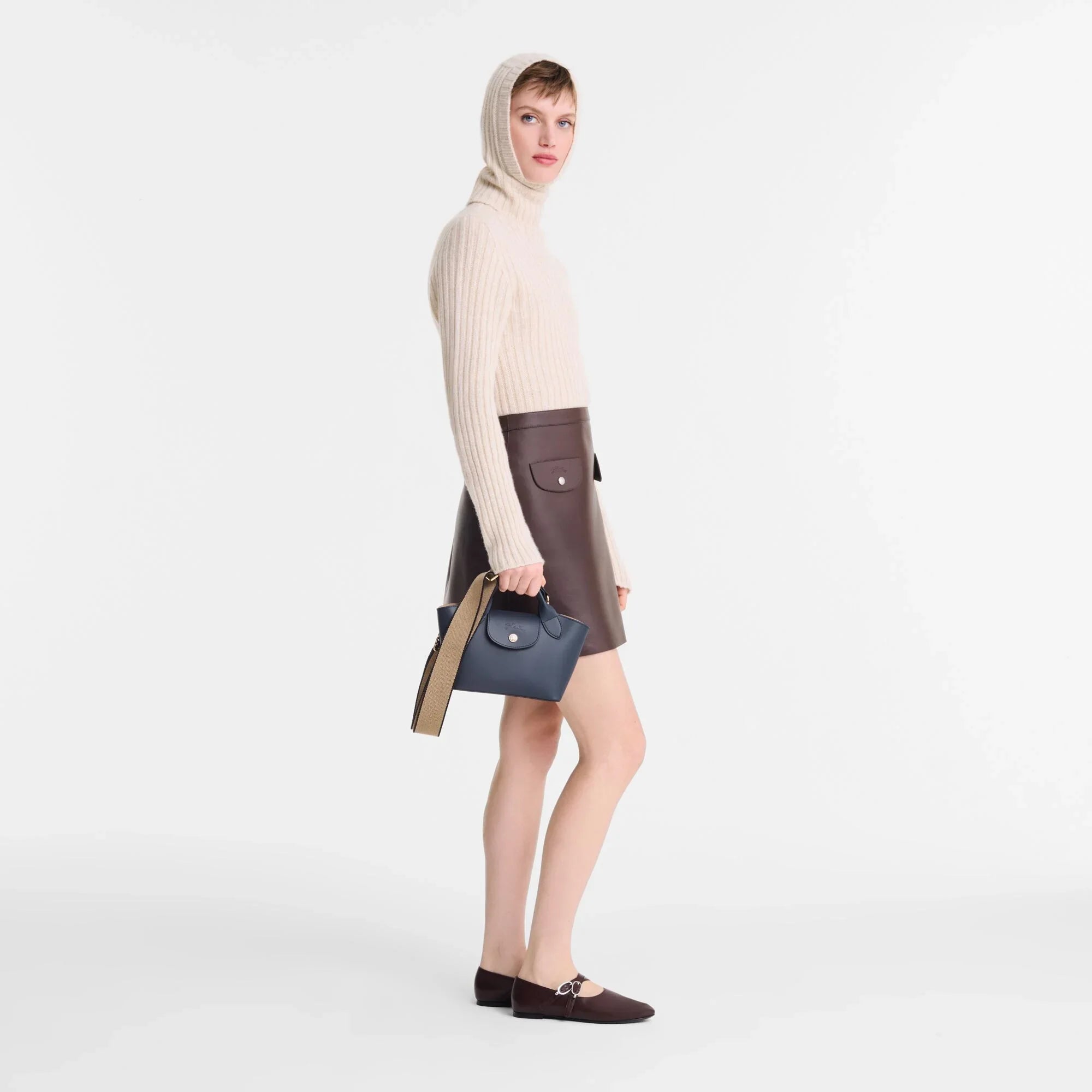 אישה עם סוודר שמנת, חצאית חומה ותיק יד כחול, אופנה יוקרתית CHOZEN