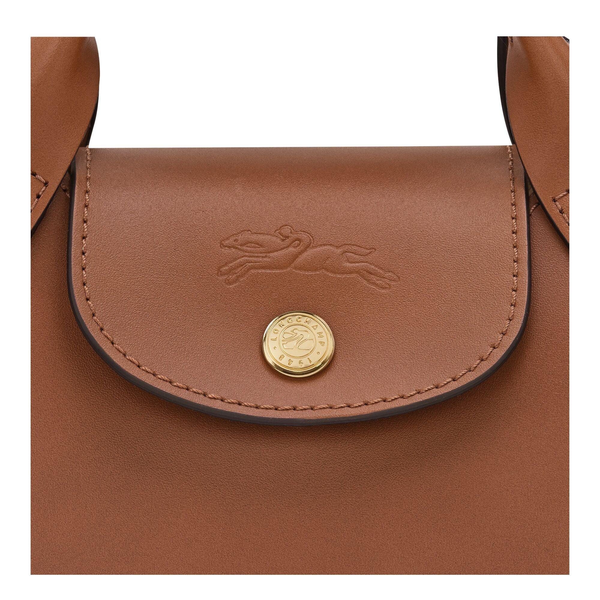 תקריב תיק עור חום יוקרתי עם כפתור זהב ולוגו מוטבע, מבית המותגים של CHOZEN