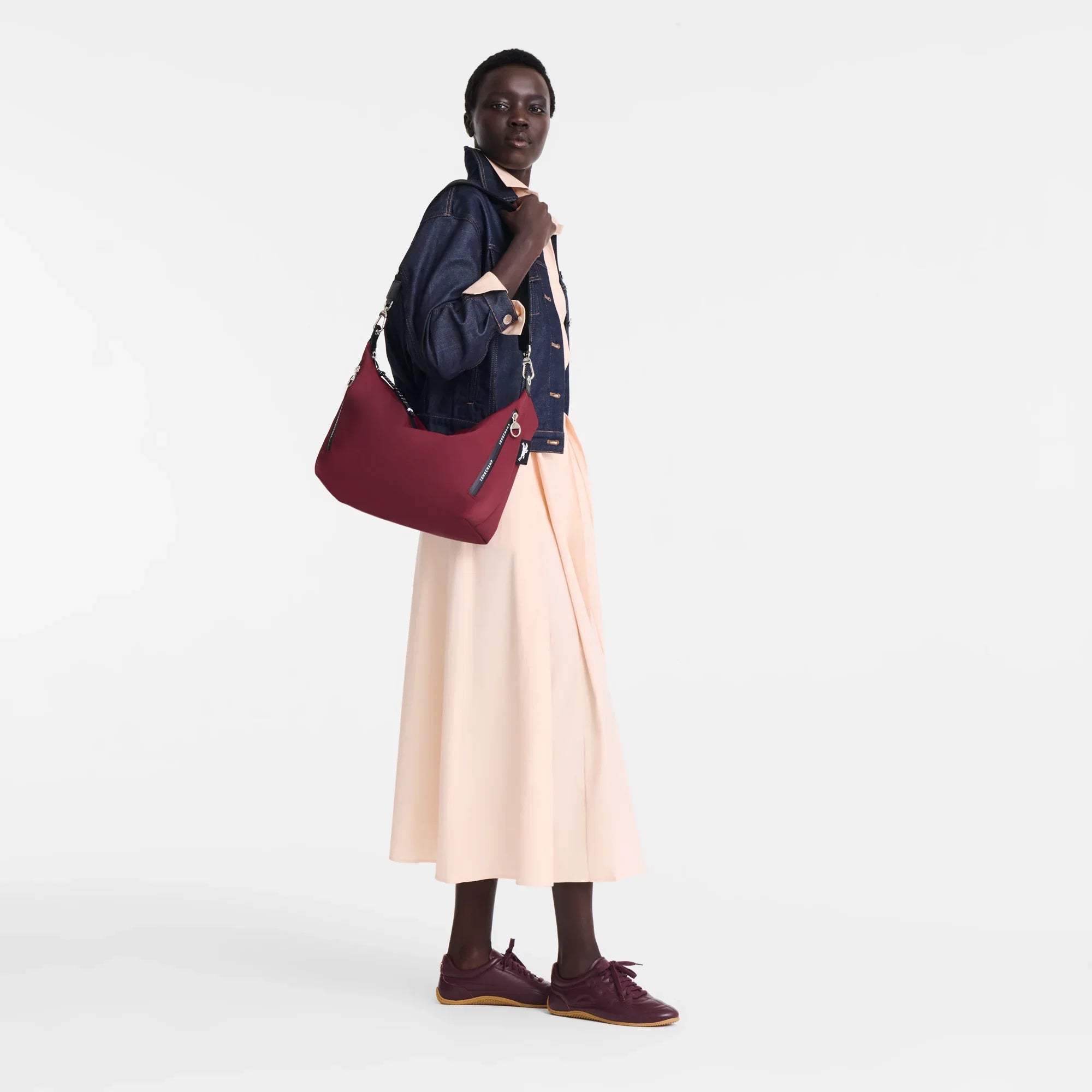 דוגמנית עם תיק צד בורדו, ג׳קט ג'ינס וחצאית בהירה, אופנה מבית CHOZEN