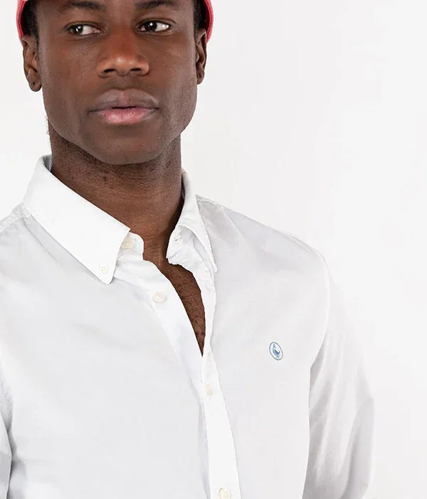 גבר לובש חולצה לבנה מכופתרת עם לוגו קטן, צילום אופנה לאתר CHOZEN