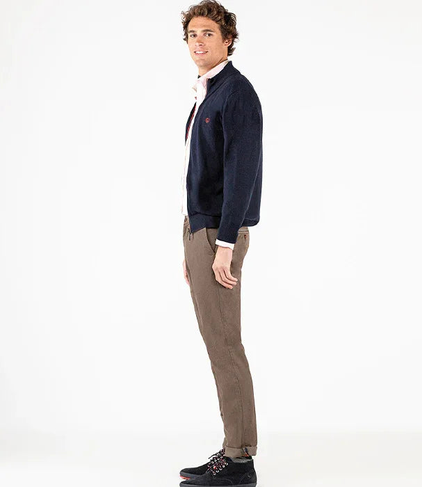 גבר לובש סוודר כחול, חולצה לבנה ומכנסיים חומים, דוגמן אופנה של CHOZEN