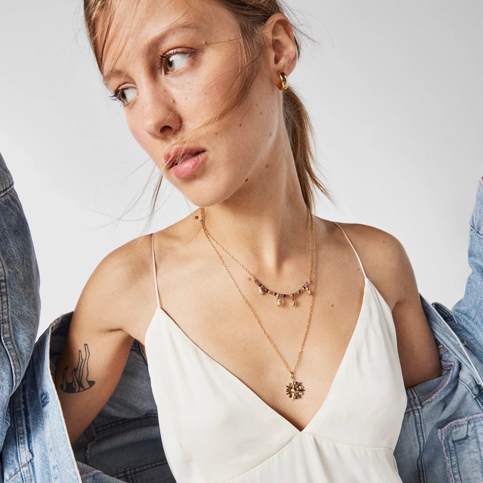 דוגמנית עם שמלה לבנה, ז'קט ג'ינס ותכשיטי גולד, צילום סטודיו לקמפיין CHOZEN