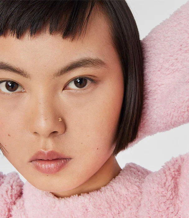 דוגמנית עם שיער קצר, לובשת חולצה ורודה מבד פליז, צילום אופנה CHOZEN