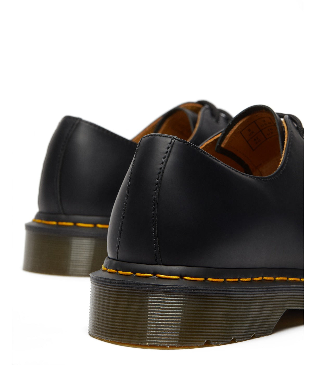 תקריב על עקבי זוג נעלי DR. MARTENS GIBSON שחורות עם תווית פנימית גלויה, מבית CHOZEN
