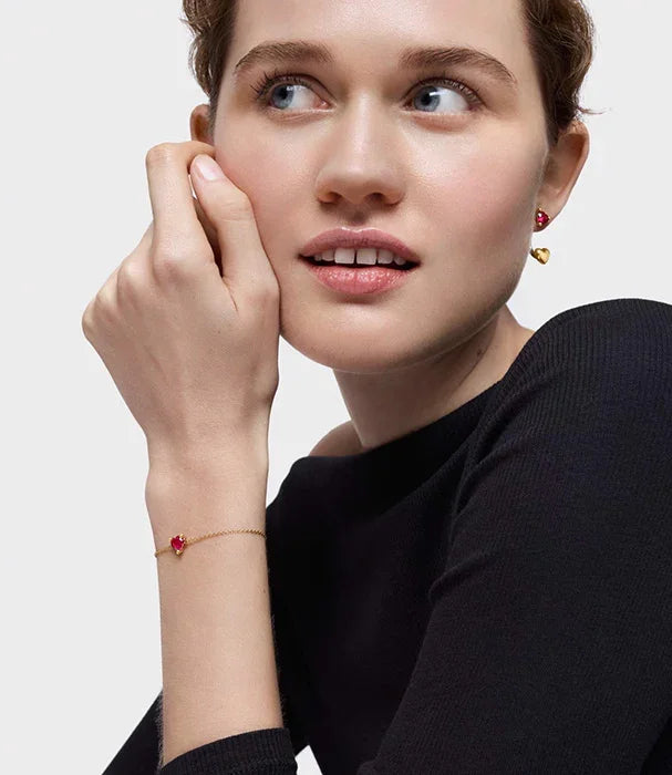 אישה עונדת עגילים וצמיד זהב עם אבני חן אדומות, תכשיטי אופנה CHOZEN