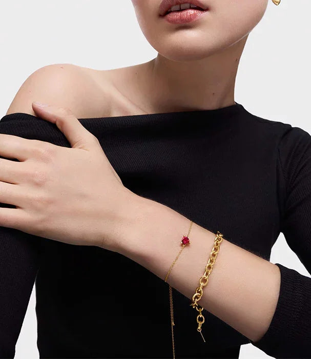 אישה לובשת חולצה שחורה עם צמידי זהב אופנתיים, תכשיטים יוקרתיים CHOZEN