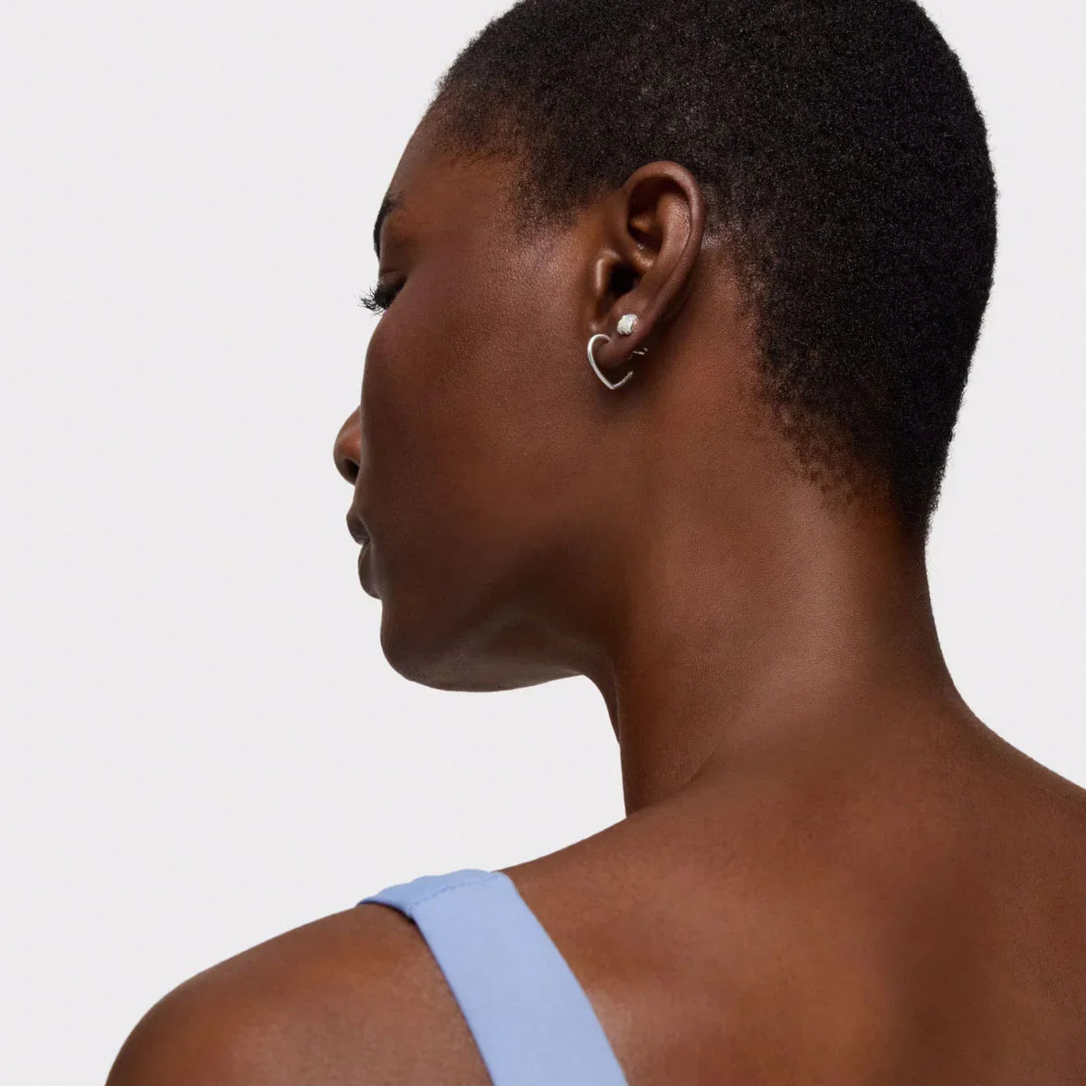 אישה עונדת עגיל כסף לאוזן בעיצוב לב, צילום צד, אופנה CHOZEN