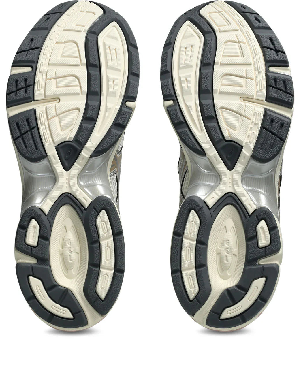 סוליות נעליים בצבע שחור ושמנת עם דפוס גומי בולט, מבט מלמטה