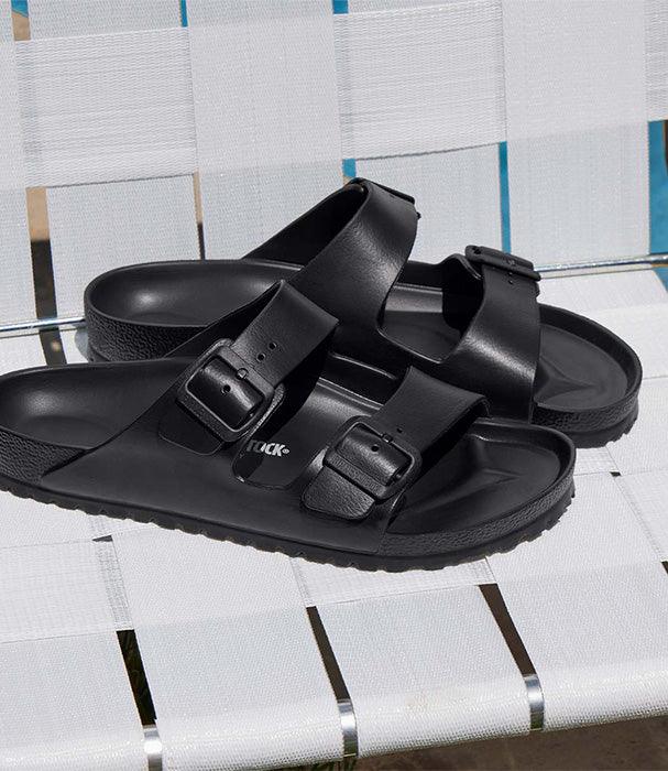סנדלי בּירקנשטוק שחורים עם רצועות כפולות, מוצגים על כיסא חוץ, CHOZEN מותגים מובילים