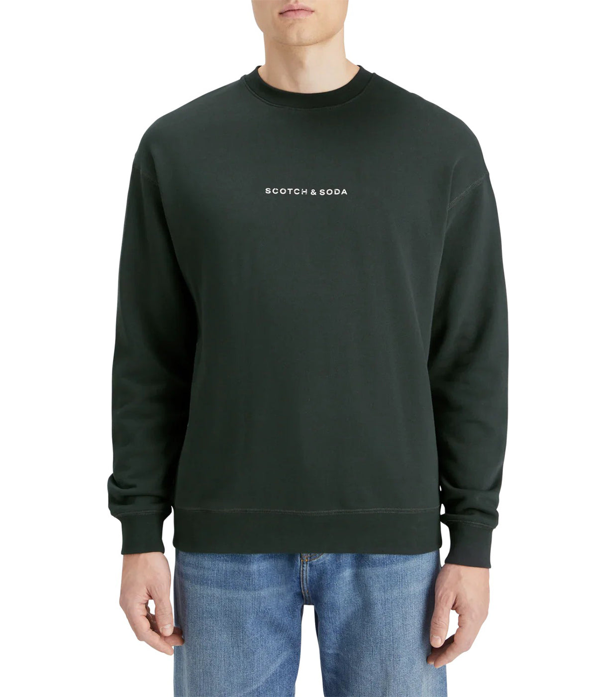 גבר לובש סווטשירט שחור עם לוגו SCOTCH & SODA, לבוש בג'ינס, רקע לבן