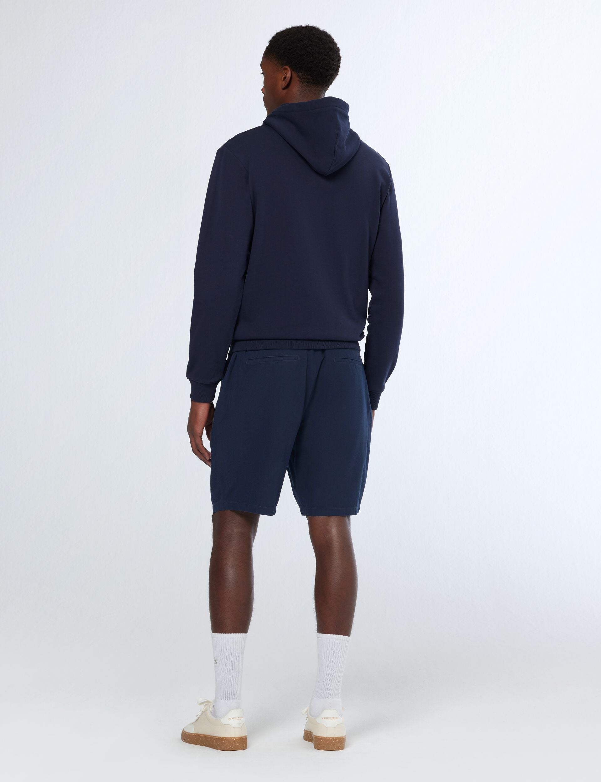 גבר עם סווטשירט קפוצ׳ון וכshorts בצבע כחול כהה מבט על הגב, צילום אולפן, CHOZEN