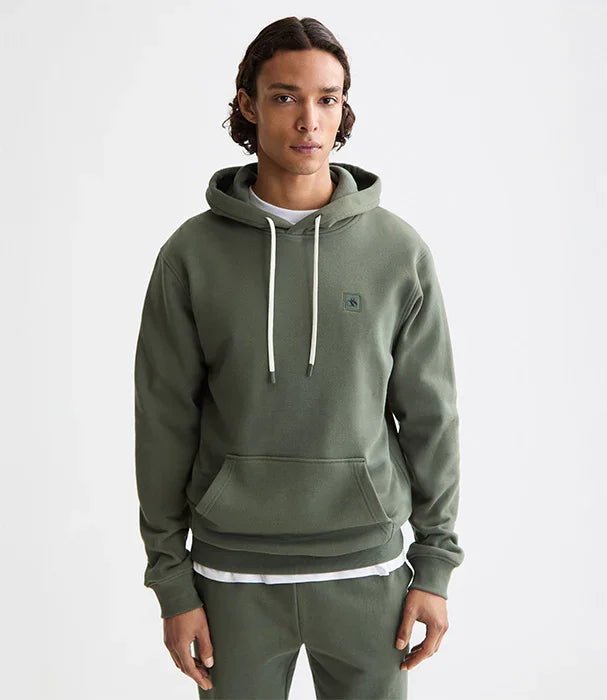 גבר לובש קפוצ'ון ירוק טרנדי מבית CHOZEN, רקע לבן, אופנת רחוב איכותית