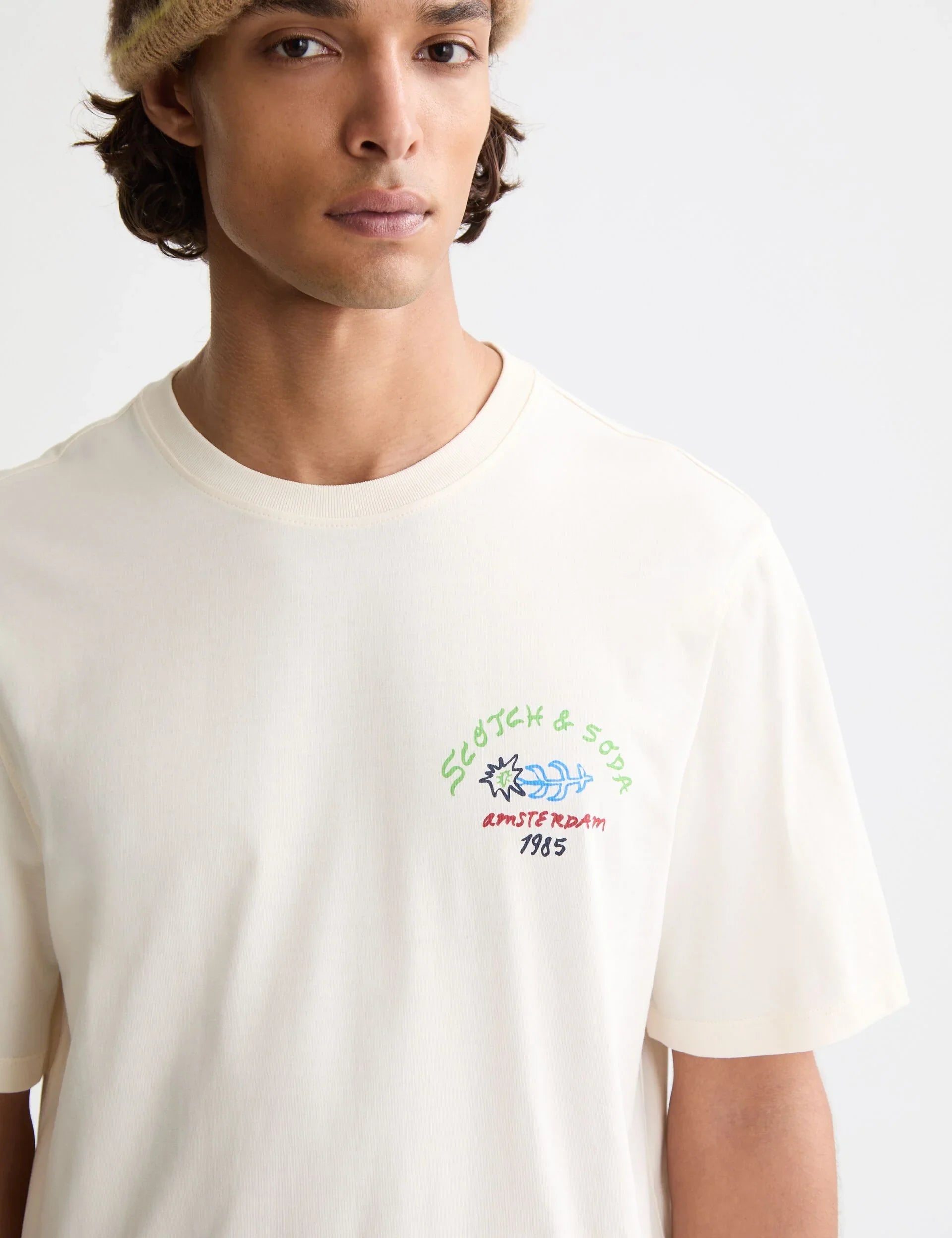גבר עם חולצת טי קרם של Scotch & Soda, הדפס אמסטרדם 1985, אופנת מותגים CHOZEN