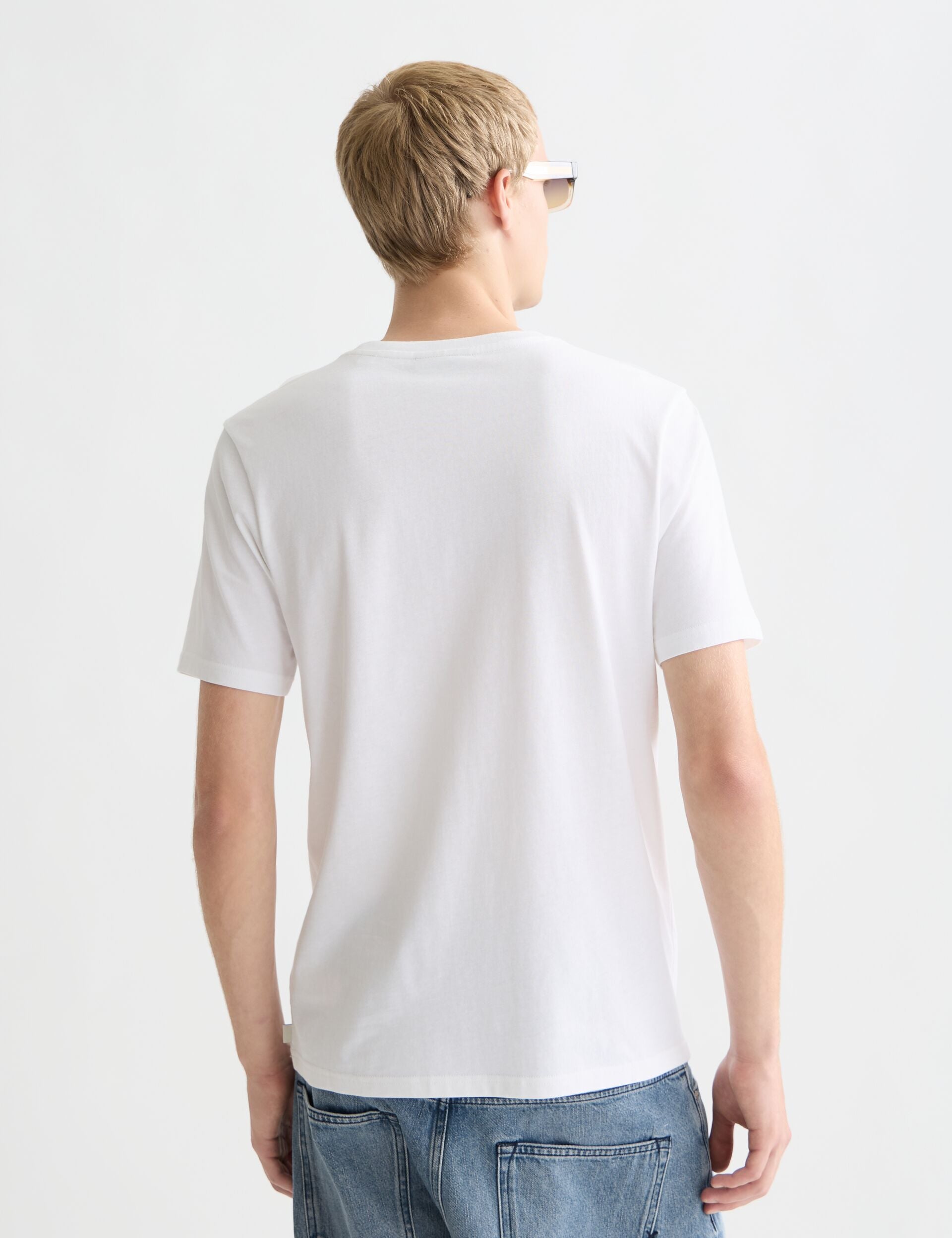 גבר לובש טי שירט לבנה קלאסית ומכנסי ג’ינס, צילום גב, אופנה מודרנית CHOZEN