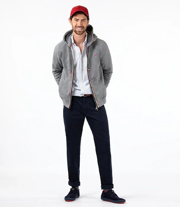 דגם גבר הלבוש קפוצ'ון אפור, חולצה מכופתרת, מכנסיים כחולים וכובע אדום, אופנה CHOZEN