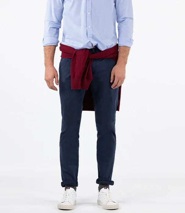 גבר לבוש חולצה כחולה, מכנסיים כחולים, סוודר אדום קשור במותניים ונעלי סניקרס לבנות, אופנת גברים CHOZEN