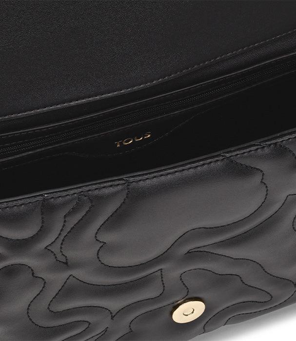 תקריב על תיק עור שחור בעיצוב יוקרתי של TOUS עם כפתור זהב, דגם מהמותגים המובילים באתר CHOZEN