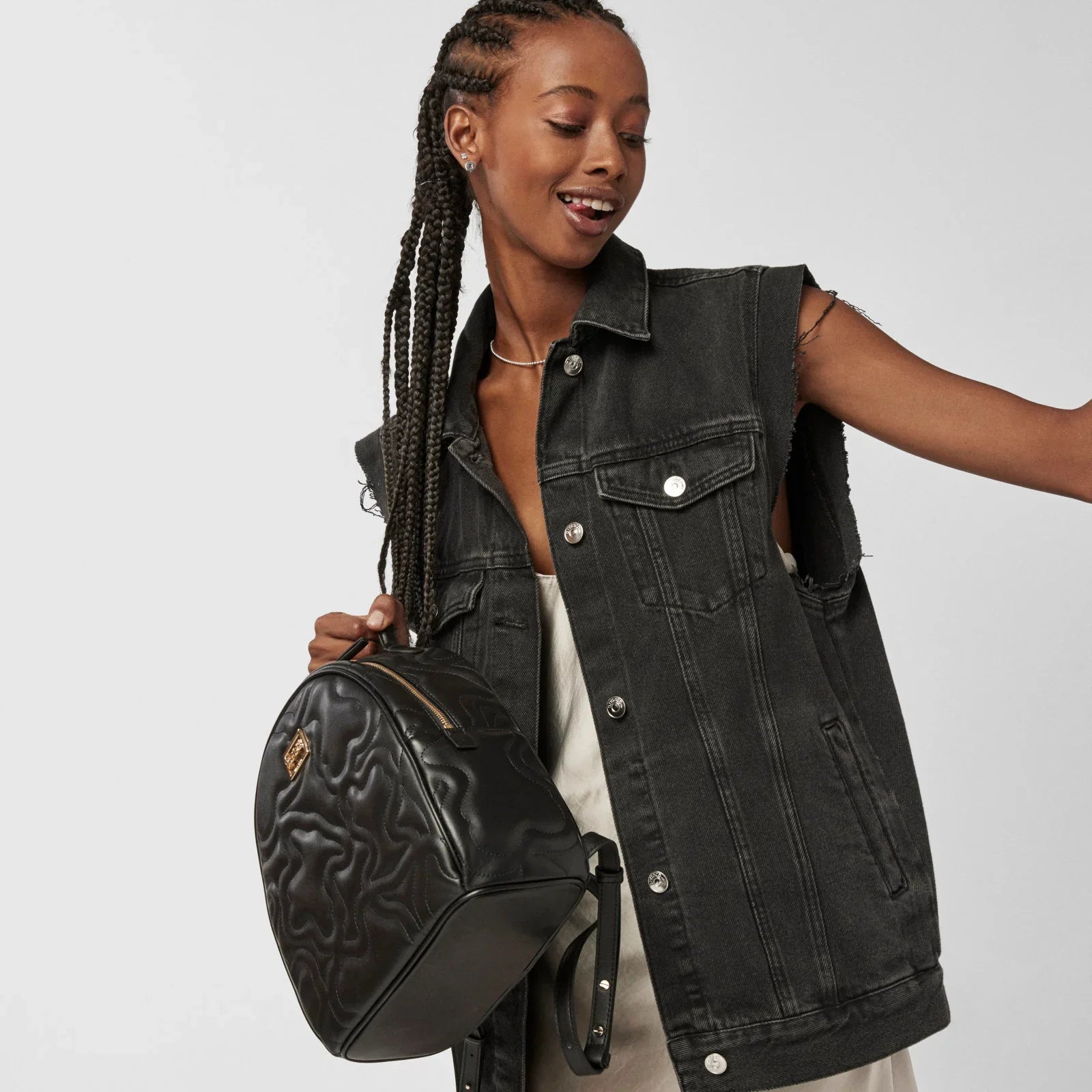 אישה לובשת וסט ג'ינס כהה ומחזיקה תיק גב מעוצב, אופנה מ-CHOZEN מותגים מובילים