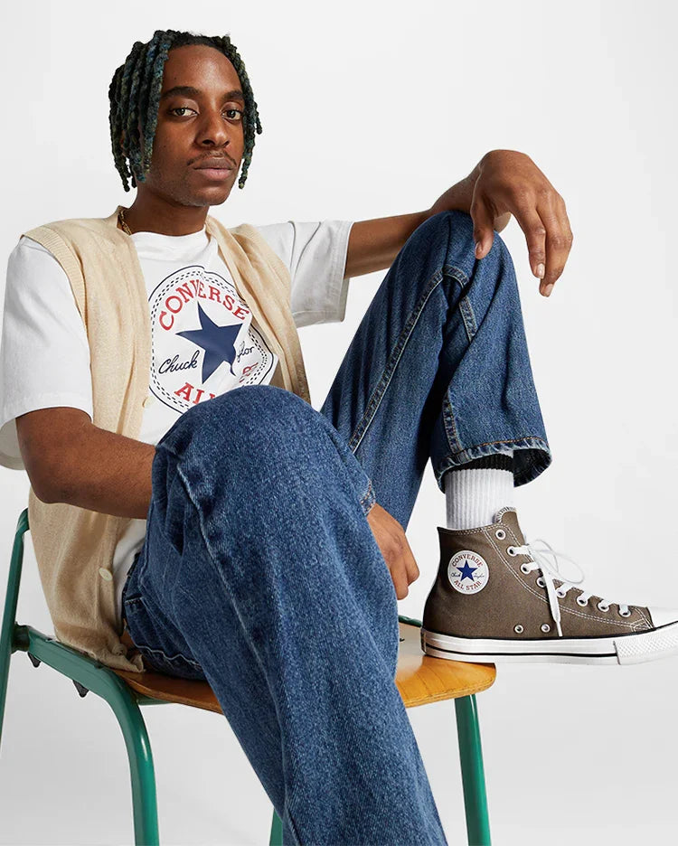 דוגמן לובש טי שירט קונברס, ג'ינס ונעלי Converse All Star על כיסא, צילום לאתר CHOZEN
