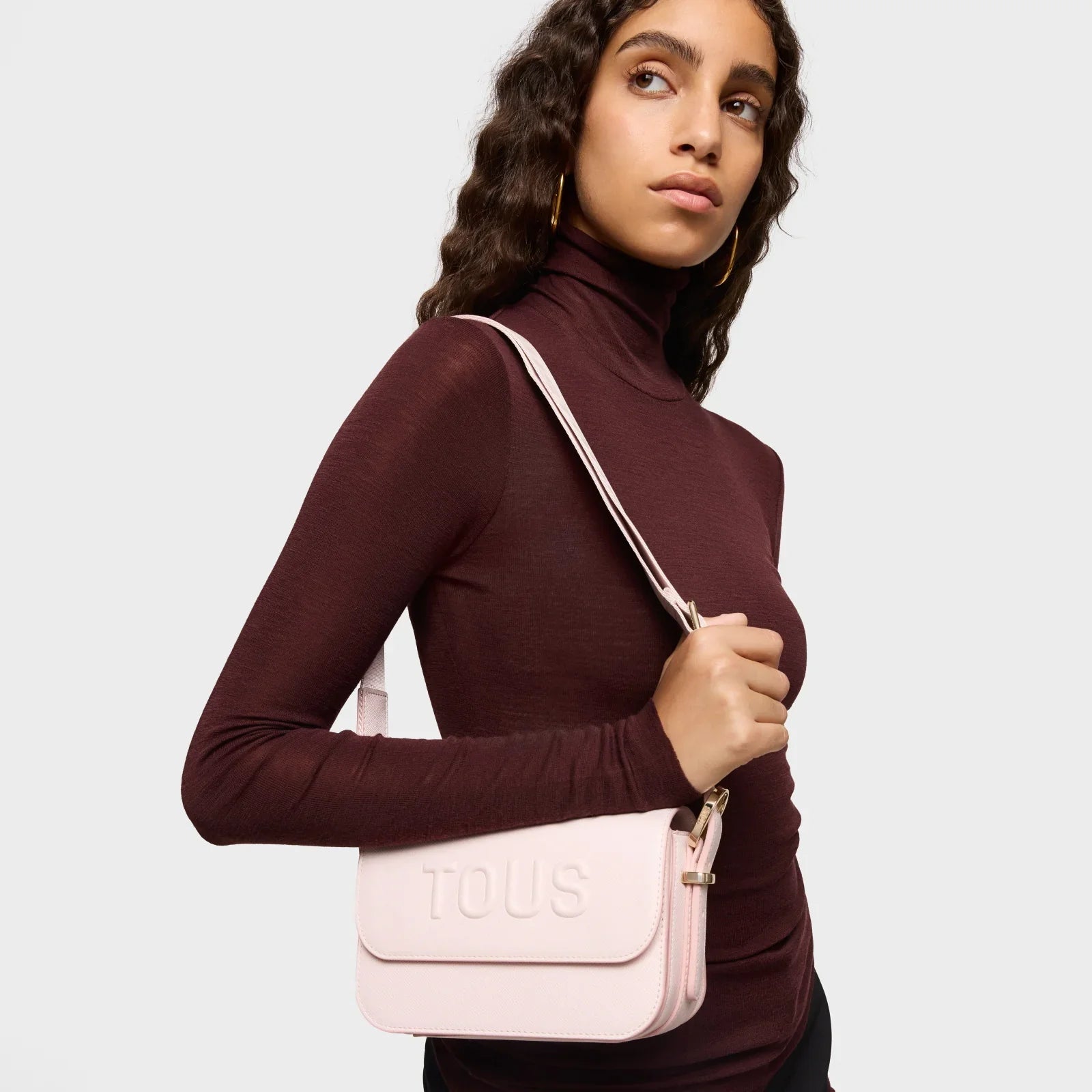 אישה עם תיק TOUS ורוד על הכתף, אופנה יוקרתית מבית קבוצת אלפא, CHOZEN מותגים מובילים