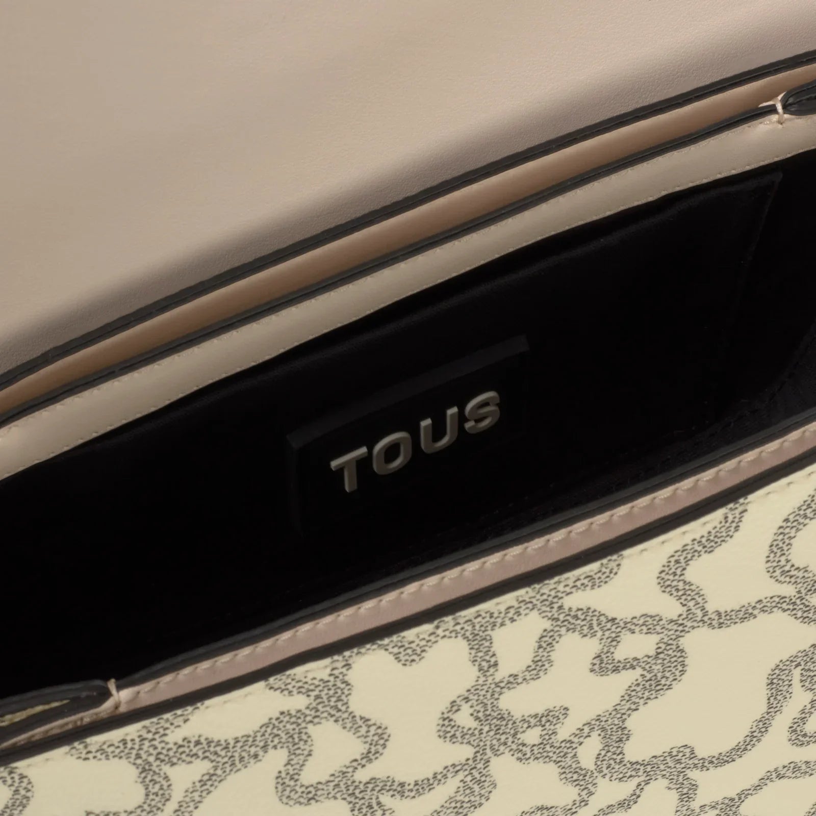 תקריב של תיק TOUS לקריאה עם דוגמת עור בהירה, מותג מהיבואן הרשמי קבוצת אלפא