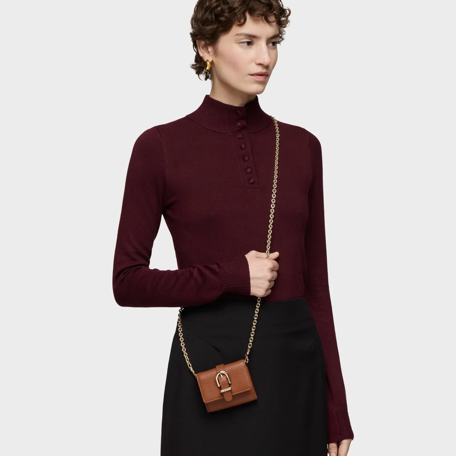 אישה עם סוודר בורדו, תיק קלאץ' חום עם רצועת שרשרת זהב, אופנה יוקרתית CHOZEN