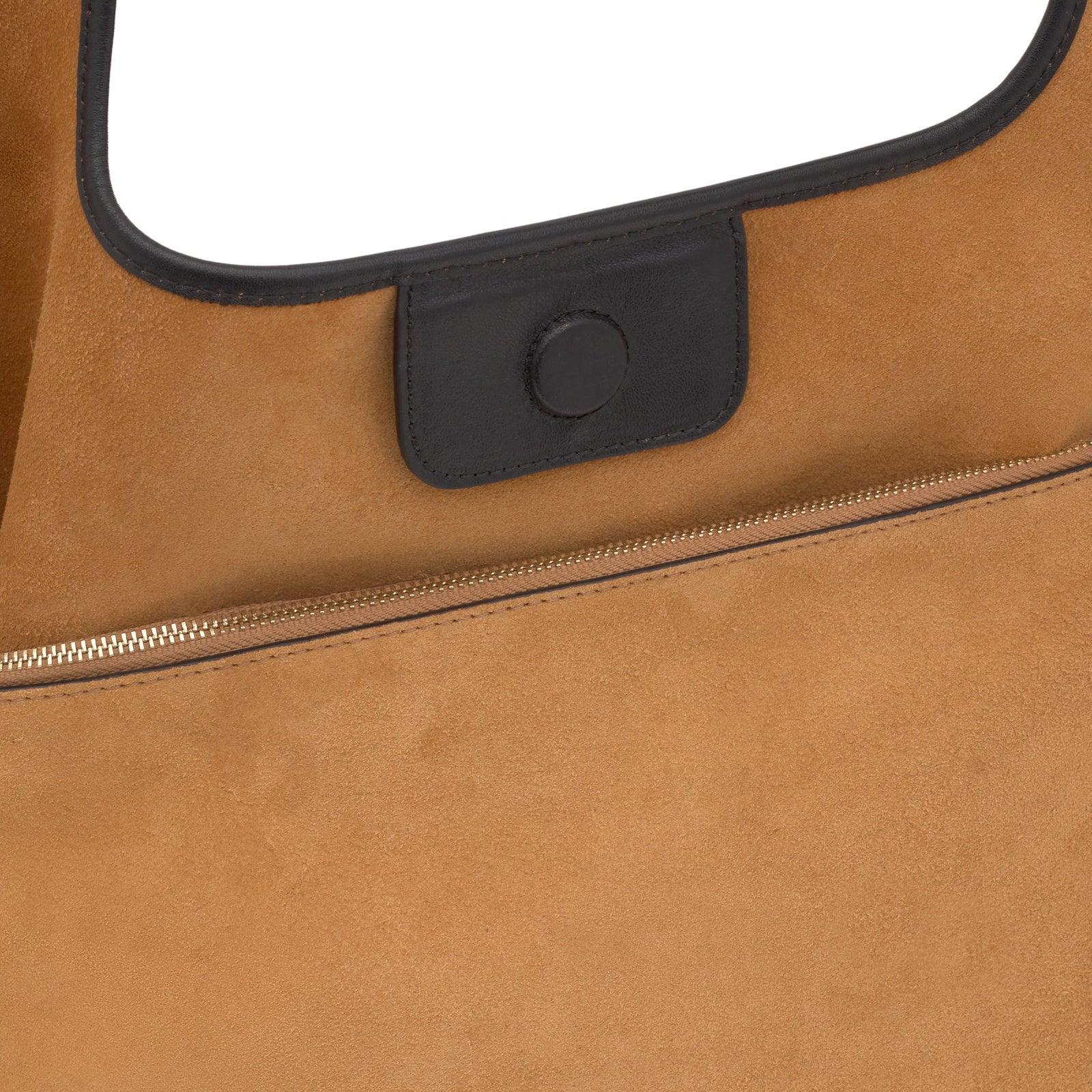 תקריב של תיק עור חום עם סגירת רוכסן, מוצר יוקרה מקבוצת אלפא CHOZEN