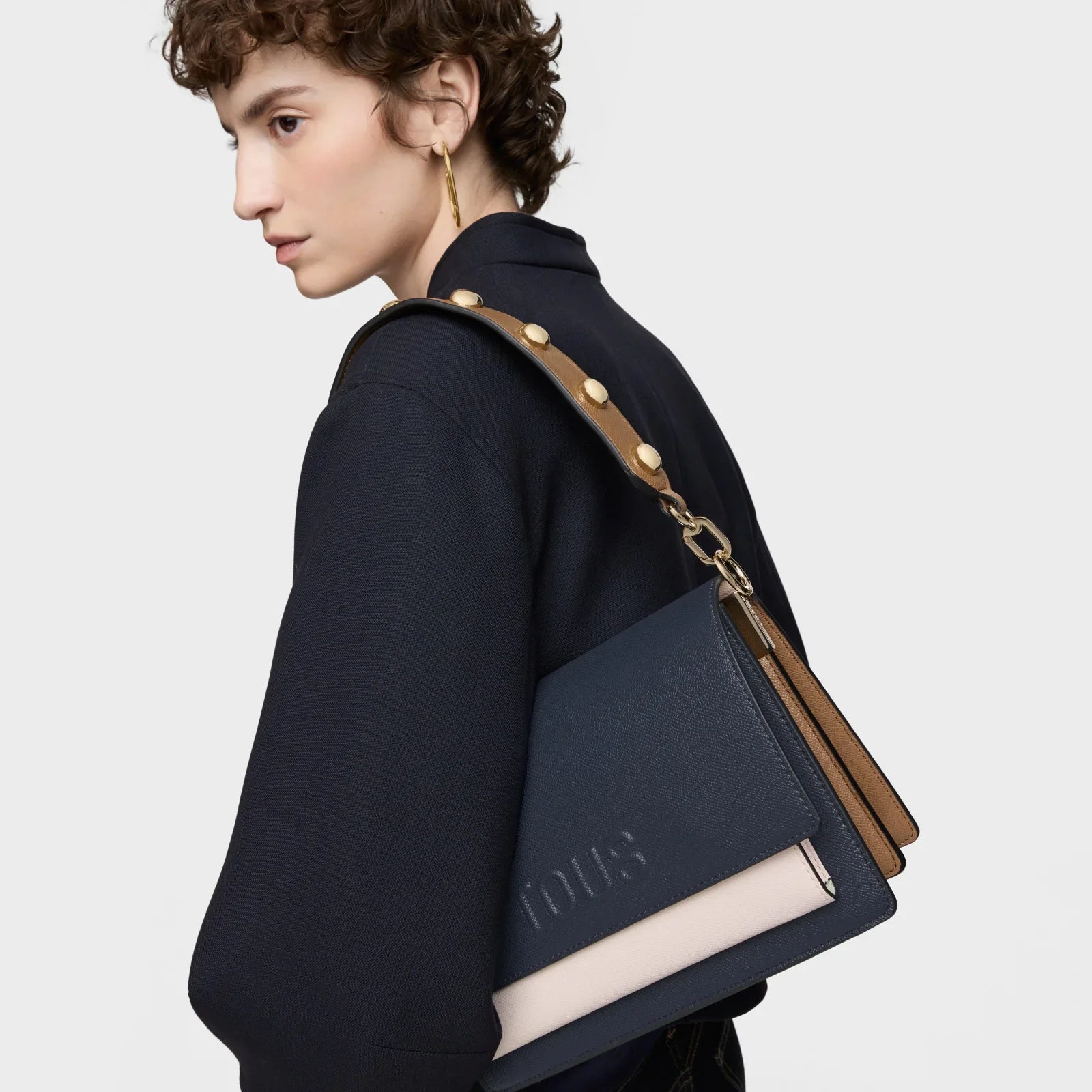 דוגמנית עם תיק עור אופנתי בצבע כחול וחום של TOUS מבית CHOZEN מותגים מובילים