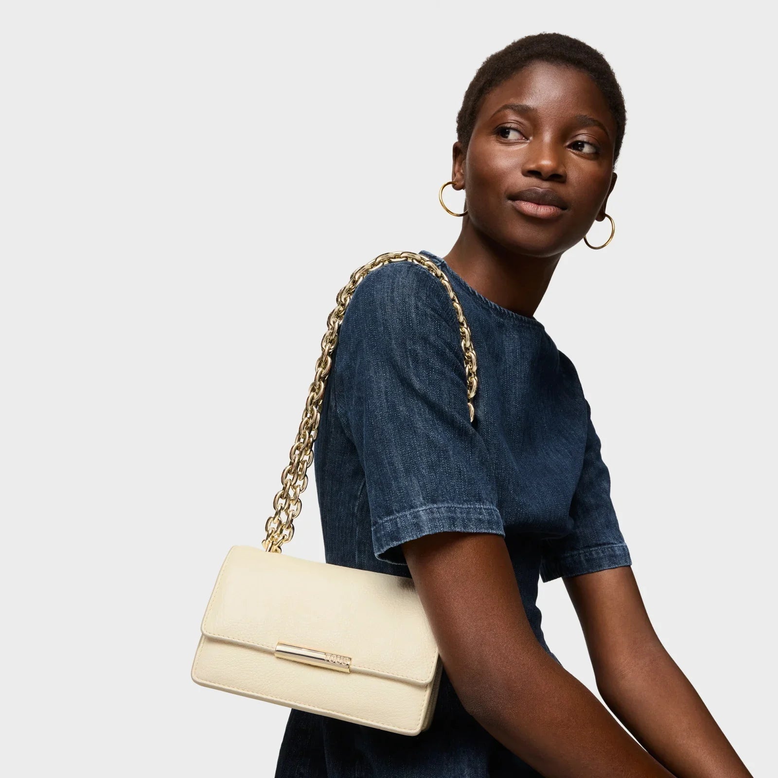 אישה עם תיק עור אלגנטי בהיר על שרשרת זהב, אופנה יוקרתית ב-CHOZEN מבית קבוצת אלפא