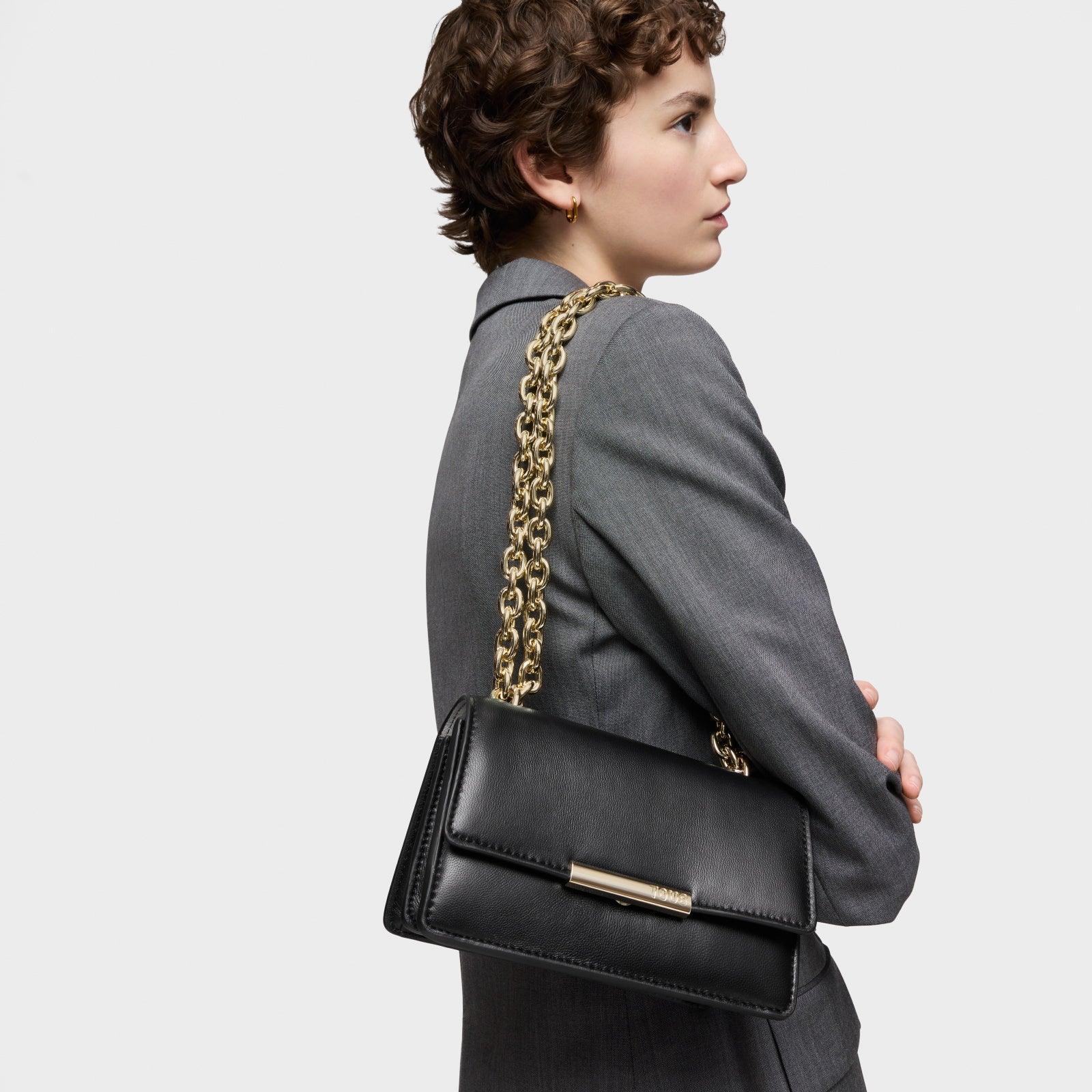 אישה בחליפה אפורה נושאת תיק עור שחור עם שרשרת זהב, CHOZEN מותגים מובילים