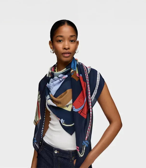 אישה עם צעיף צבעוני מבית CHOZEN, לבושה חולצה לבנה ומכנס כהה, רקע לבן נקי