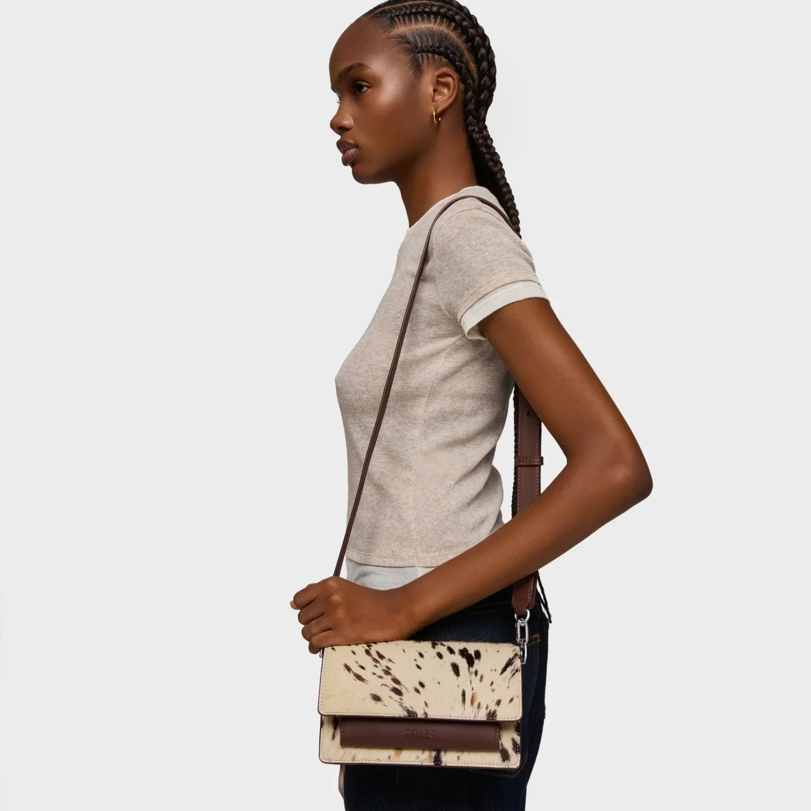 אישה עם תיק צד חום ולבן מדגם יוקרתי, אופנה מבית CHOZEN, צילום בסטודיו רקע לבן