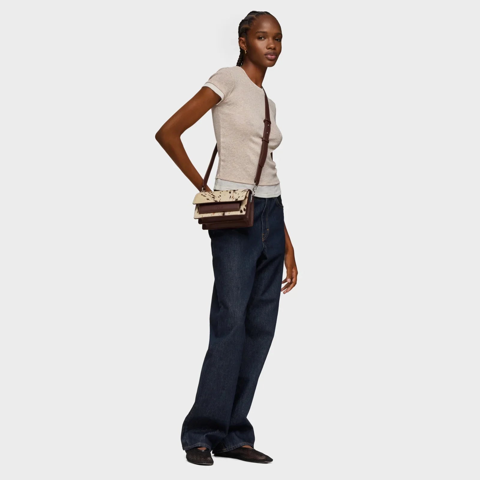 אישה לובשת חולצה בהירה, ג'ינס רחב ותיק צד משולב חום ולבן, אופנה CHOZEN