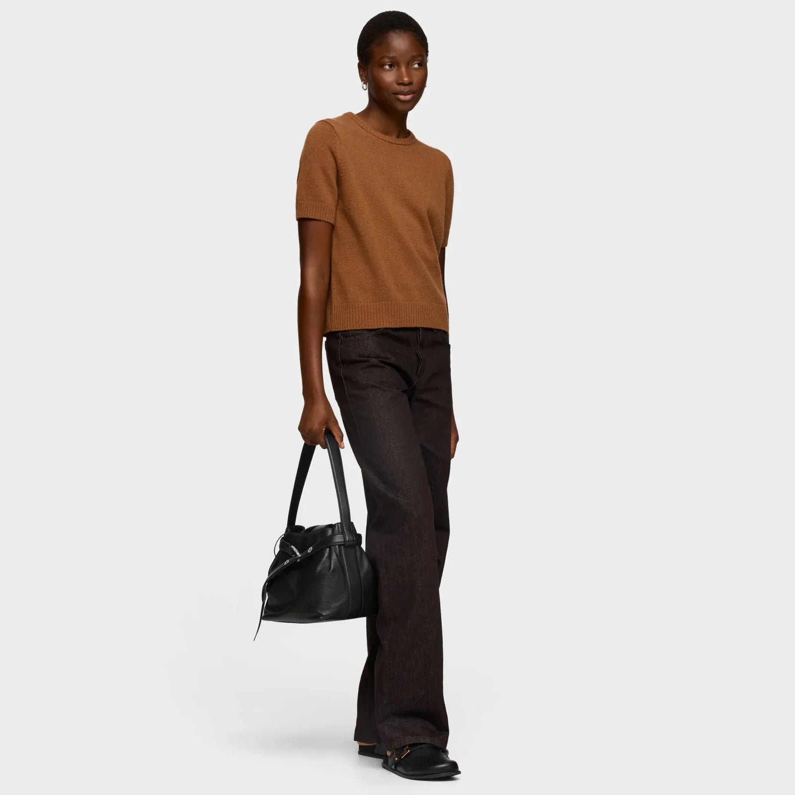 אישה עם חולצה חומה, מכנסיים כהים ותיק שחור אופנתי, אופנה עכשווית CHOZEN