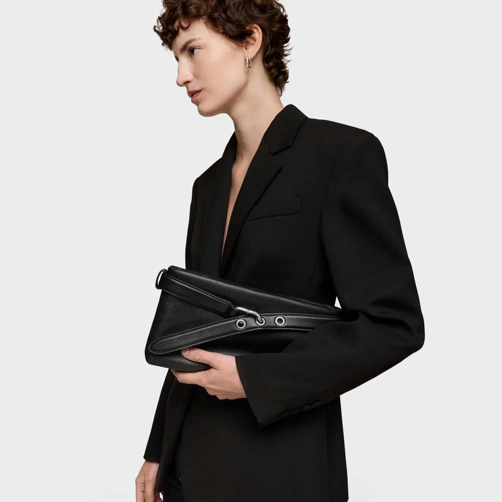 אישה בלבוש אלגנטי עם בלייזר שחור ותיק עור שחור, אופנה יוקרתית CHOZEN