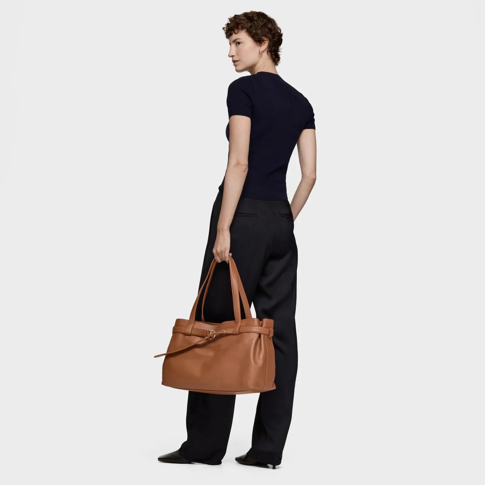 אישה עם תיק יד חום מעור, לוק אופנתי, מוצג ב-CHOZEN קבוצת אלפא