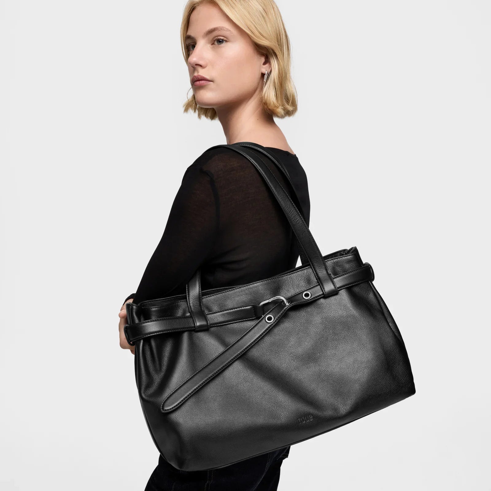 אישה מחזיקה תיק עור שחור אופנתי של מותג מוביל, צילום בסטודיו, CHOZEN אלפא