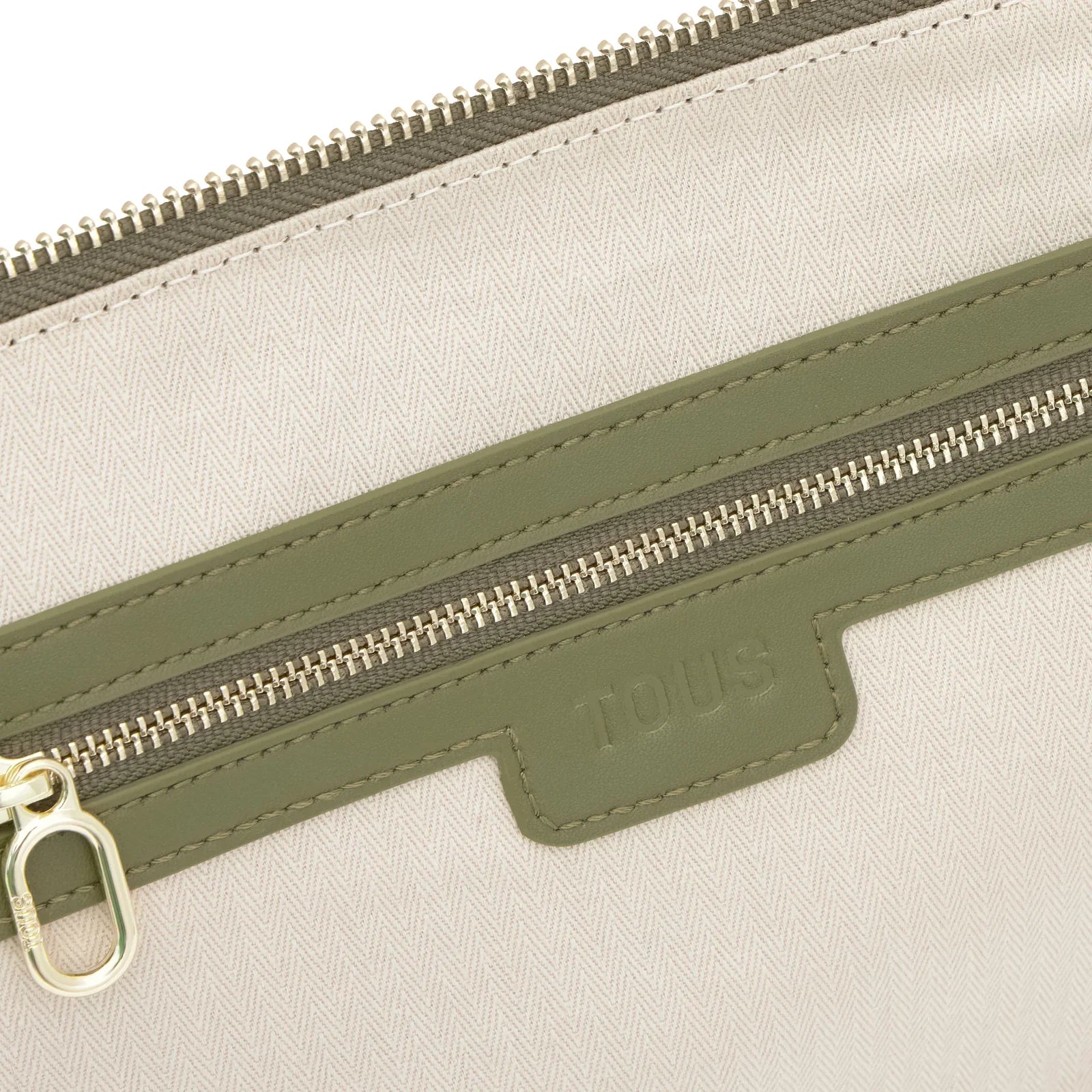 קלוז-אפ של תיק TOUS בצבע בז' עם דיטיילים ירוקים וריצ'רץ', מותג מבית קבוצת אלפא